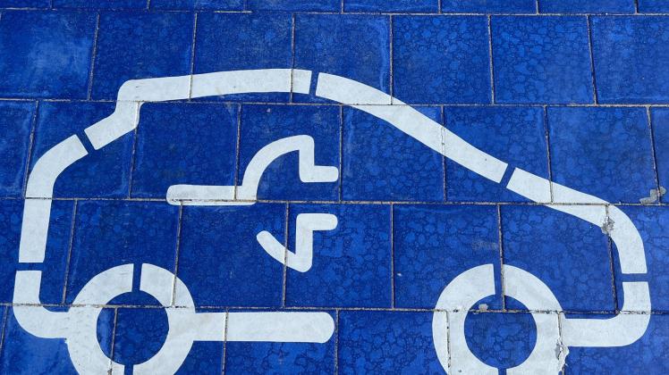 ARCHIV - Ein Symbol für Elektro-Autos an einer Ladestation. Foto: Christoph Dernbach/dpa
