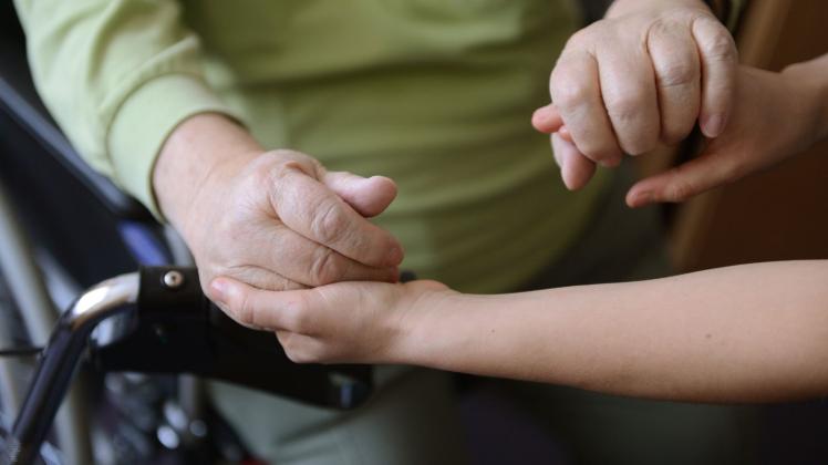 ILLUSTRATION - Eine Frau hält die Hände eines pflegebedürftigen Senioren. Foto: Jens Kalaene/dpa-Zentralbild/dpa/Symbolbild ILLUSTRATION - Eine Frau hält die Hände eines pflegebedürftigen Senioren. Foto: Jens Kalaene/dpa-Zentralbild/dpa/Symbolbild