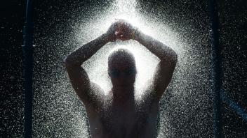 ARCHIV - Es hilft der Haut, wenn man sich nach jeder Runde Schwimmen im Bad duscht. Foto: Julian Stratenschulte/dpa/dpa-tmn