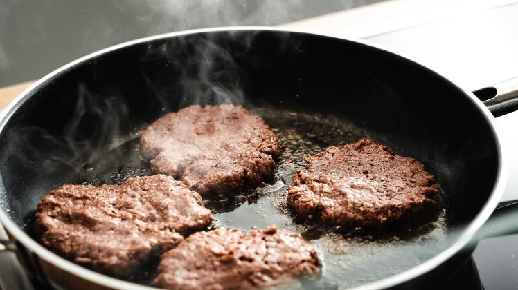 06 February 2022: Vegan hamburger patties made from pea protein, vegetable vegan meat replacement burger is fried in a h