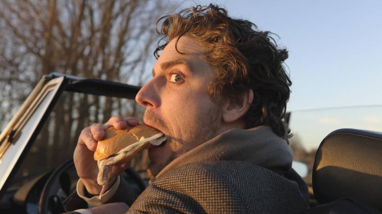 Germany Hamburg Man eating fish sandwich in classic cabriolet car model released PUBLICATIONxINxGE