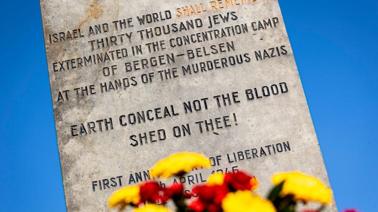 Blumen liegen vor einem Gedenkstein auf dem Gelände der Gedenkstätte Bergen-Belsen. Foto: Moritz Frankenberg/dpa