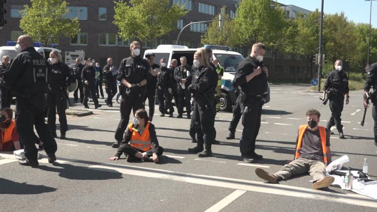 Aktivisten haben sich am Montag in Bremen mit Sekundenkleber auf einer Straße festgeklebt. Aktivisten haben sich am Montag in Bremen mit Sekundenkleber auf einer Straße festgeklebt.