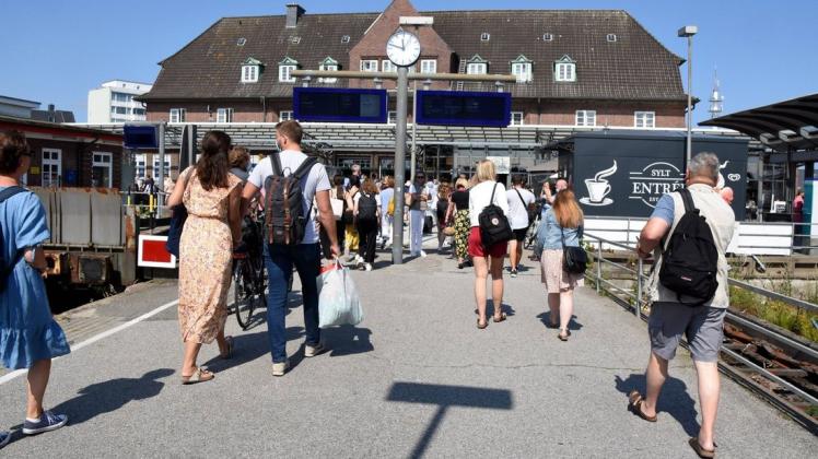 Reisende und Schülergruppen warten auf einen Zug nach Sylt.