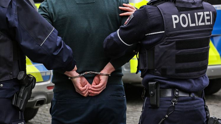 Symbolbild Thema Polizei, zwei Polizisten mit einer Person mit Handschellen Symbolbild zum Thema Polizei am 22.01.2020 i