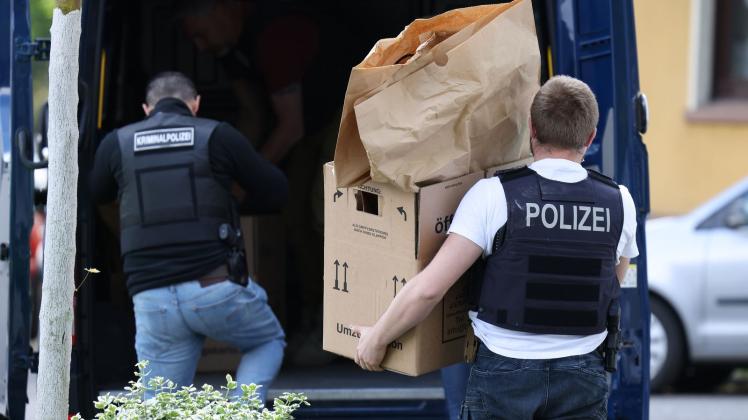Polizisten tragen Gegenstände aus dem Wohnhaus des Tatverdächtigen. Foto: David Young/dpa