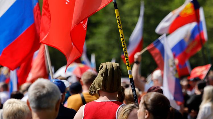 Demonstranten schwenken Russland-Fahnen. Vor dem Hintergrund des Kriegs in der Ukraine haben über 1000 Menschen in Köln
