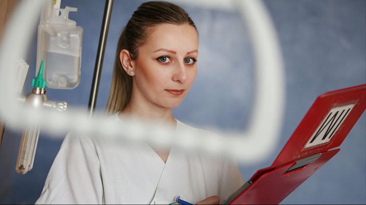 Eine Krankenschwester hinter einem medizinischen Gerät. 
