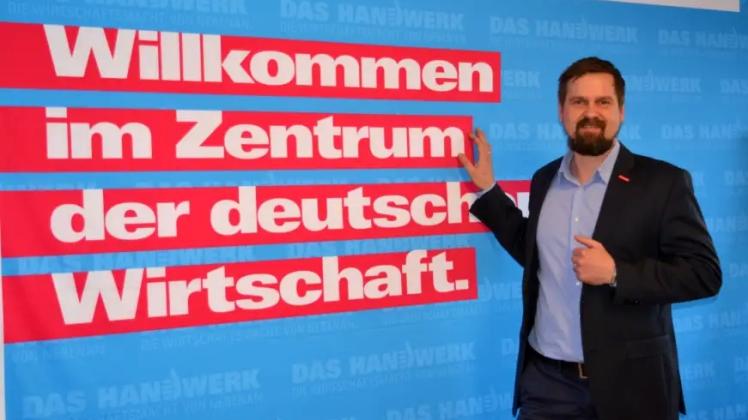 Mann vor großem Schriftzug