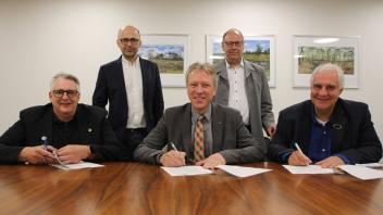 Die drei Schulleiter Olaf Hirt (sitzend von links), Andreas Bitzer und Jörg Leppin unterzeichneten den Vertrag. Carsten Hillgruber (stehend links) und Dr. Klaus Fahrner freuen sich über die Kooperation.