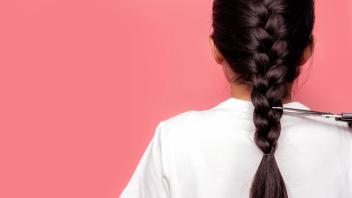Back view of Asian woman with braided hairstyle is cutting with scissors for donate to cancer patients. Hair donation fo