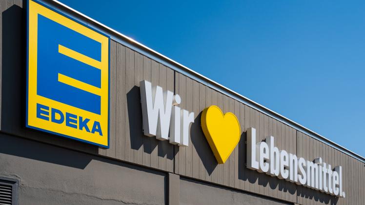 Gersthofen, Bavaria, Germany - 28 April 2022: Edeka grocery store retailer, company logo with advertising slogan We love