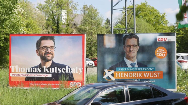 Wahlplakate mit Portraits von Ministerpräsident Hendrik Wüst (r) und Herausforderer Thomas Kutschaty von der SPD. Foto: Oliver Berg/dpa