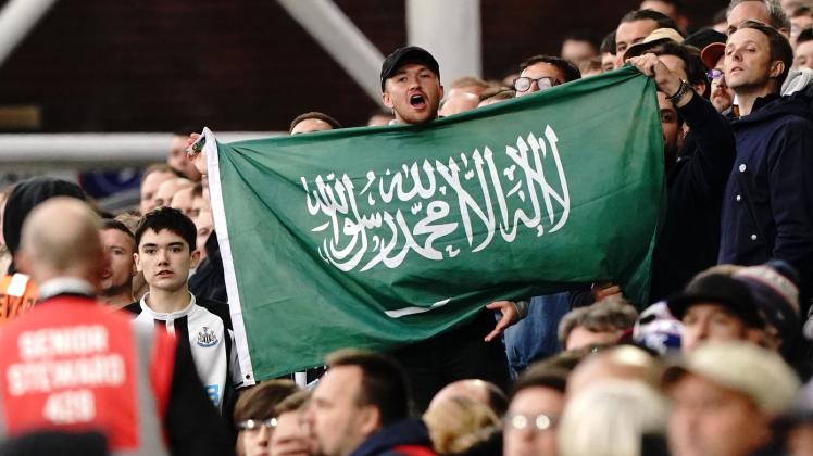 ARCHIV - Ein Fan von Newcastle United hält die Fahne von Saudi-Arabien während eines Spiels hoch. Foto: Jonathan Brady/PA Wire/dpa