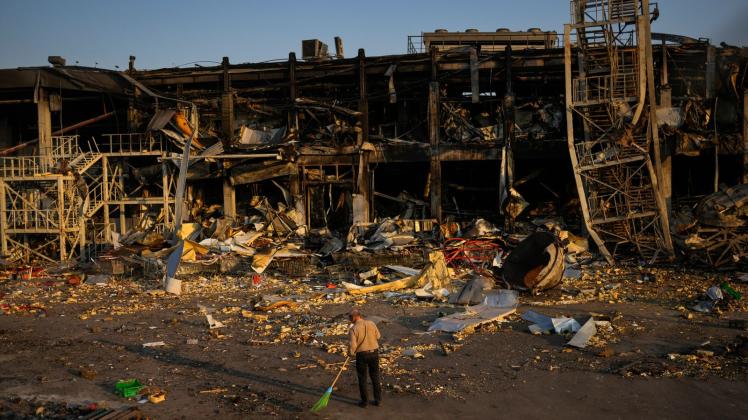 Ein Mann fegt in Odessa Trümmer zusammen. Das Einkaufzentrum vor ihm wurde am 9. Mai durch einen russischen Raketenangriff zerstört. Foto: Francisco Seco/AP/dpa
