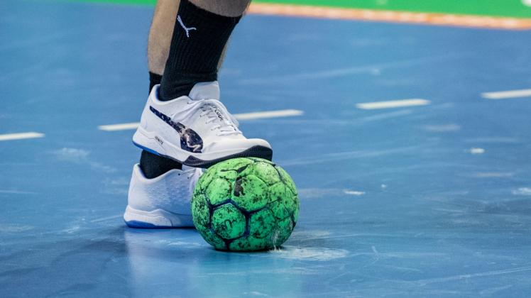 ARCHIV - Ein Spieler hält einen Handball mit dem Fuß fest. Foto: Andreas Gora/dpa/Symbolbild