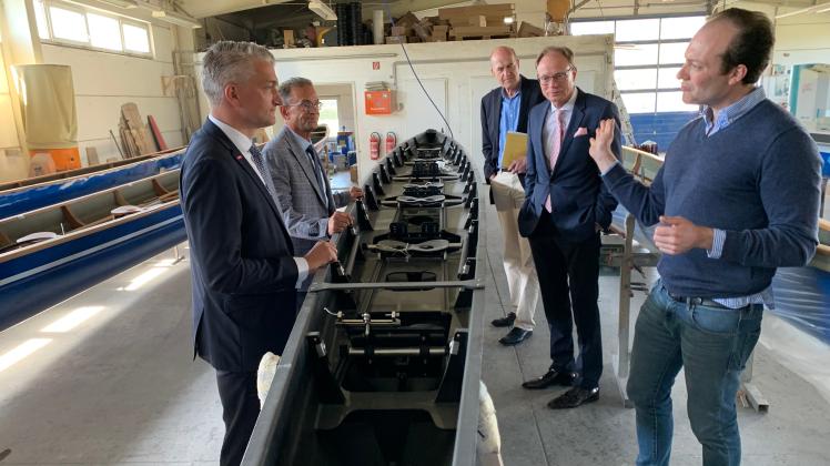 Bootsbauermeister Eike Baumgarten erläutert den Gästen an einem Gig-Doppelfünfer
neuester Bauart die einzelnen Produktionsschritte. Von links: Hauptgeschäftsführer Dr. Gunnar Pohl,

Handwerkskammerpräsident Uwe Lange, Referatsleiter Stephan Mücke, Staatssekretär Jochen Schulte und
Firmeninhaber Eike Baumgarten.