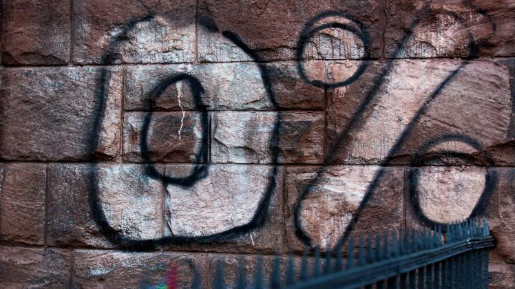 0 Prozent, 0 , Graffiti auf einer Steinwand, eiserner Zaun mit Spitzen, universelles Symbol für Ertragslosigkeit, bzw. n