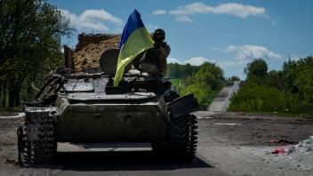May 13, 2022, Ruska Lozova, Kharkiv Oblast, Ukraine: A Ukrainian troop waves a Ukraine flag while riding in a Russian tr