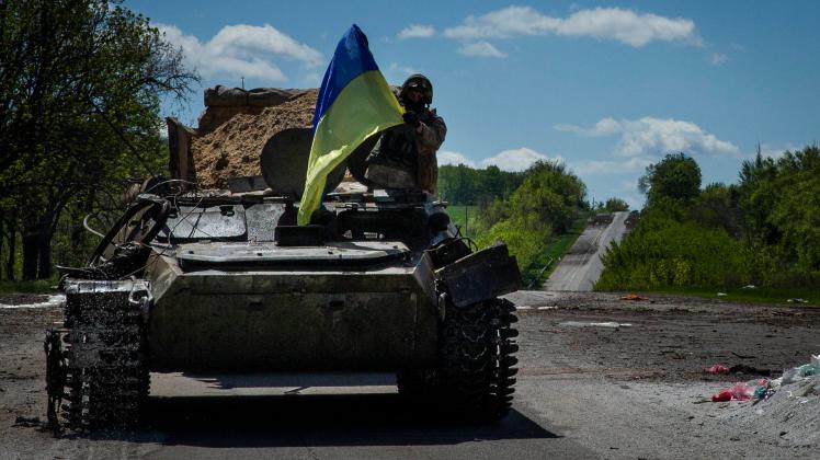 May 13, 2022, Ruska Lozova, Kharkiv Oblast, Ukraine: A Ukrainian troop waves a Ukraine flag while riding in a Russian tr