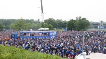 Fans des FC Schalke 04 empfangen die Mannschaft zur Aufstiegsfeier auf dem Rudi-Assauer-Platz. Foto: Tim Rehbein/dpa