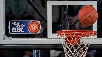 ARCHIV - Ein Ball fliegt auf den Korb zu, an dem ein Logo der Basketball-Bundesliga klebt. Foto: Axel Heimken/dpa/Symbolbild
