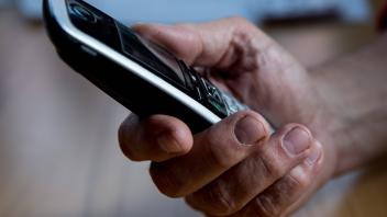 Bamberg, Deutschland 29. April 2021: Die Hand eines älteren Menschen hält ein Telefon, Mobilteil in der Hand. Viele Seni