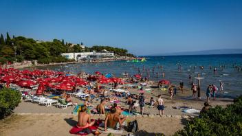 ARCHIV - Badegäste sonnen sich am Strand Bacvice in Kroatien. Die rekordverdächtige Inflation und der Ukraine-Krieg scheinen die Reiselust der Menschen in Deutschland nach zwei Corona-Jahren nicht zu dämpfen. Foto: Fernando Gutierrez-Juarez/dpa-Zentralbild/dpa