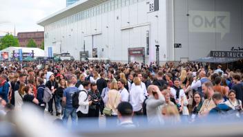 Zahlreiche Messe-Besucher stehen bei der Digitalmesse OMR in Hamburg zwischen den Messehallen. Foto: Jonas Walzberg/dpa