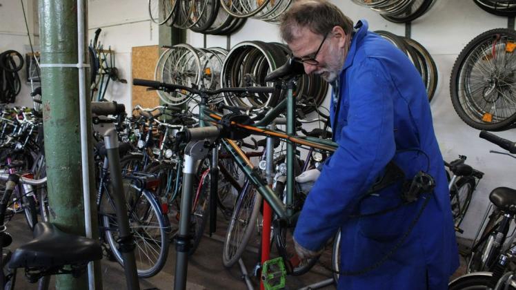 Um ein anderes Rad passend für einen Geflüchteten zu machen, schraubt Jürgen Hofeldt zunächst die Pedale aus einem anderen Fahrrad heraus.