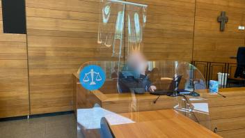 Der Angeklagte sitzt hinter einer Scheibe im Landgericht Traunstein. Foto: Britta Schultejans/dpa - ACHTUNG: Der Angeklagte wurde auf Wunsch seiner Anwältin gepixelt