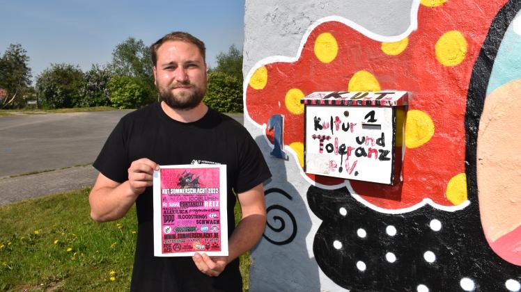 Timmi Hennig vom Kultur und Toleranz-Verein Gadebusch hält ein Poster der Sommerschlacht 2022 in die Kamera.