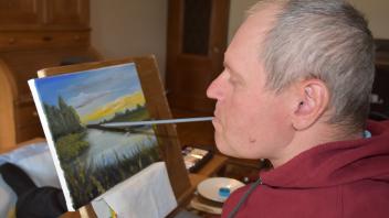 Petro Holonko bei seinem kreativen Schaffen. Mit dem Mund malt der Ukrainer wunderschöne Gemälde.