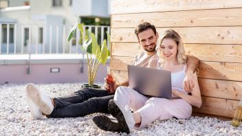 Smiling young couple sharing laptop on sunny day model released property released, PESF03536