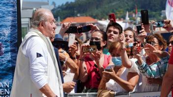 Juan Carlos (l), Altkönig von Spanien, spricht mit Schaulustigen vor einem Empfang in einem Nautikclub vor einer Segelveranstaltung in Sanxenxo. Foto: Álvaro Ballesteros/EUROPA PRESS/dpa
