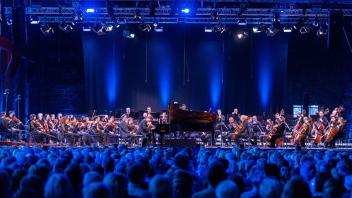 Das New York Philharmonic Orchestra spielt gemeinsam mit Jan Lisiecki am Klavier beim ersten Konzert im ehemaligen Kraftwerk Peenemünde auf der Ostseeinsel Usedom. Foto: Jens Büttner/dpa