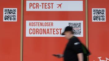 Ein Passant geht an einem Corona-Testcenter in Dresden entlang. Foto: Sebastian Kahnert/dpa