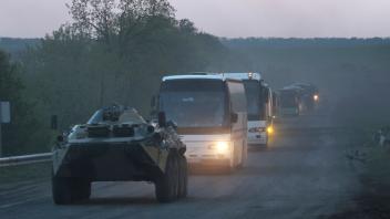 dpatopbilder - Ein APC der Miliz der sogenannten Volksrepublik Donezk begleitet Busse mit ukrainischen Soldaten zur Strafkolonie in Oljoniwka, nachdem sie das belagerte Stahlwerk Azovstal in Mariupol verlassen haben. Foto: Uncredited/AP/dpa