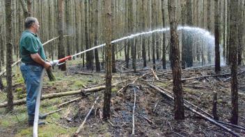 Waldbrandnachsorge durch die Landesforst: Thomas Kühl wässert den verbrannten Waldboden in der Nähe des Töpferhofes Hohenwoos.