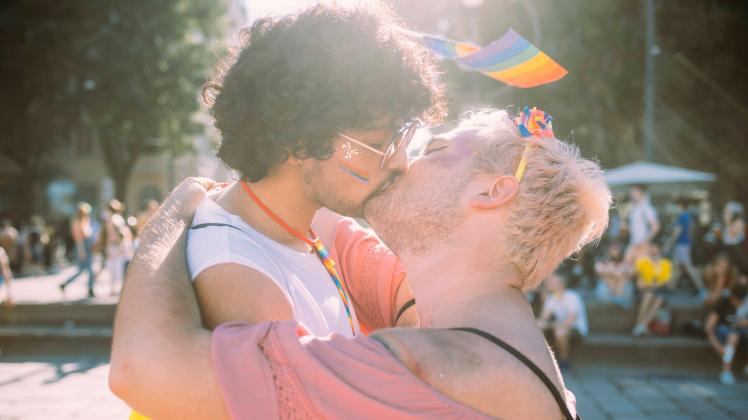 Gay couple kissing on footpath model released Symbolfoto MEUF03676