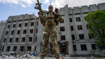 LPR Russia Ukraine Military Operation 8190732 13.05.2022 A serviceman is pictured in front of an administrative building