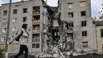Eine Frau vor einem zerstörten Gebäude in Bachmut im Gebiet Donezk.