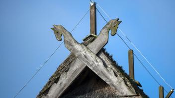 ARCHIV - Ein hölzernes Giebelkreuz mit Pferdeköpfen an einem reetgedeckten Fachwerkhaus auf dem Gelände des Freilichtmuseums Schwerin-Mueß. Foto: Jens Büttner/dpa-Zentralbild/ZB/Archivbild