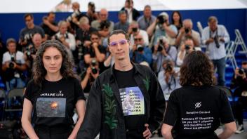 Darya Bassel (l), Maksym Nakonechnyi (M) und Yelizaveta Smith (r) auf dem roten Teppich in Cannes. Foto: Daniel Cole/AP/dpa