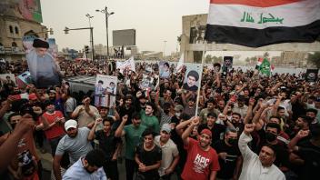 Anhänger des schiitischen Geistlichen al-Sadr nehmen an einer Kundgebung auf dem Tahrir-Platz teil. Foto: Ameer Al-Mohammedawi/dpa