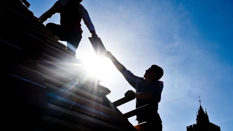 ARCHIV - Dachdecker sind oft ungeschützt der prallen Sonne ausgesetzt. Das erhöht die Gefahr, an Hautkrebs zu erkranken. Foto: Patrick Pleul/dpa/dpa-tmn/Archivbild