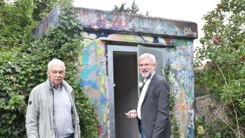 Schließen die Tür auf zu einem Erinnerungsort: Dr. Norbert Boese (links) und Dr. Carsten Jöhnk an einem der Eingänge zum ehemaligen Luftschutzbauwerk in Annenheide.