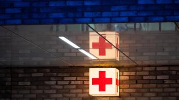 Ein Leuchtkasten mit einem roten Kreuz hängt vor der Notaufnahme eines Krankenhauses. Foto: Julian Stratenschulte/dpa/Symbolbild