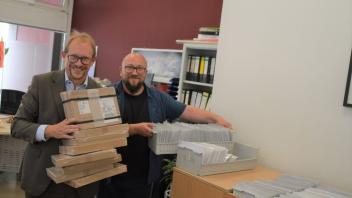 Oberbürgermeister Tobias Bergmann und der Leiter des Bürgerbüros, Michael Chlosta (rechts), zeigen die frisch von der Bundesdruckerei eingetroffenen Reisedokumente.