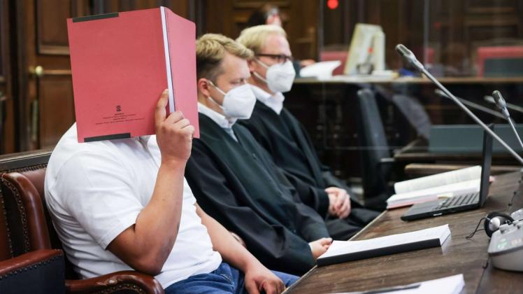 Der Angeklagte (links) sitzt zu Beginn des Prozesses neben seinen Anwälten Dennis Dördrechter (Mitte) und Christian Denzel im Gerichtssaal im Strafjustizgebäude.